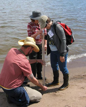 Master Naturalists using a turbidity tube to assess Lake Superior water quality