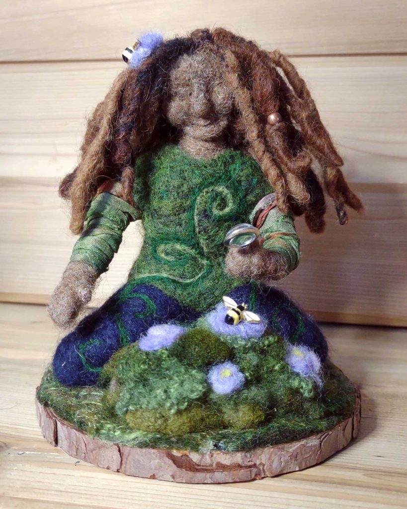 A woman holds a magnifying glass to a bumble bee